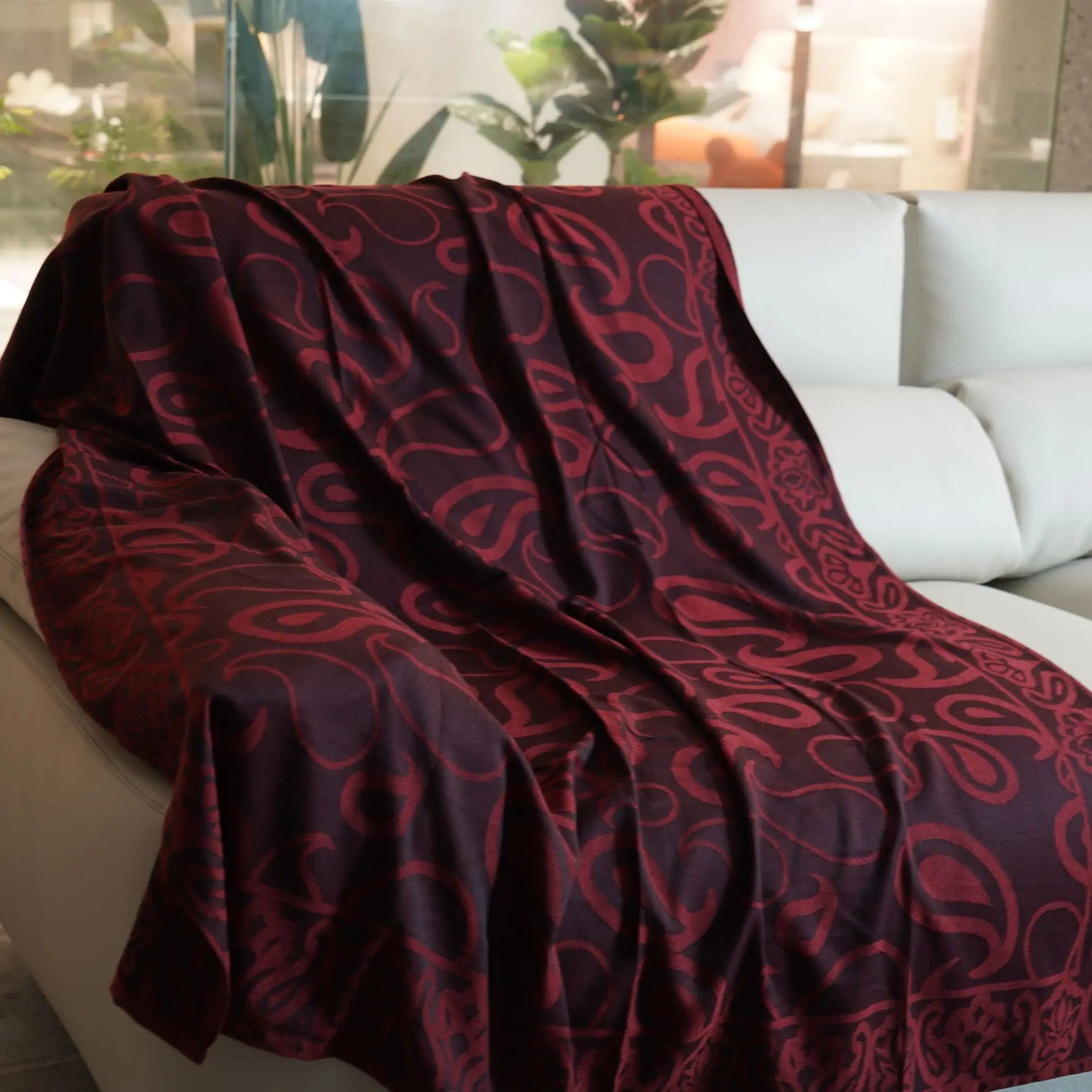 Cette couverture en tissu bordeaux et noir présente un motif abstrait de formes curvilignes élégant, donnant un aspect luxueux et raffiné à l'image.