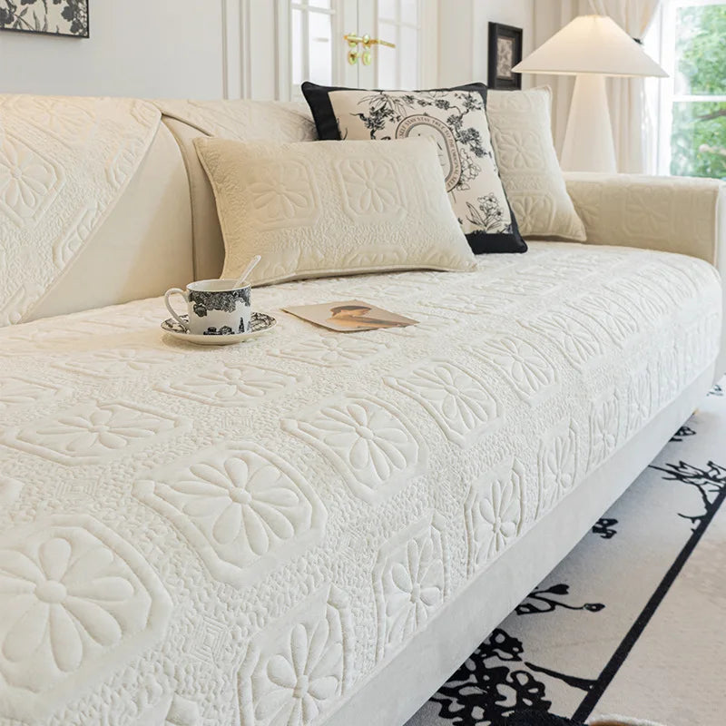 Couvrelit confortable et décoratif avec des motifs floraux blancs sur un canapé près d'une fenêtre dans un intérieur lumineux et élégant.