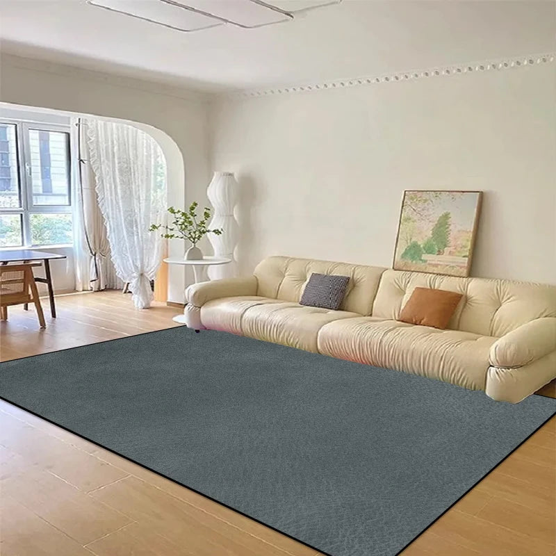 Un salon élégant avec un grand canapé beige, des rideaux blancs et un tapis vert foncé sur un parquet en bois clair, créant une ambiance apaisante et lumineuse.
