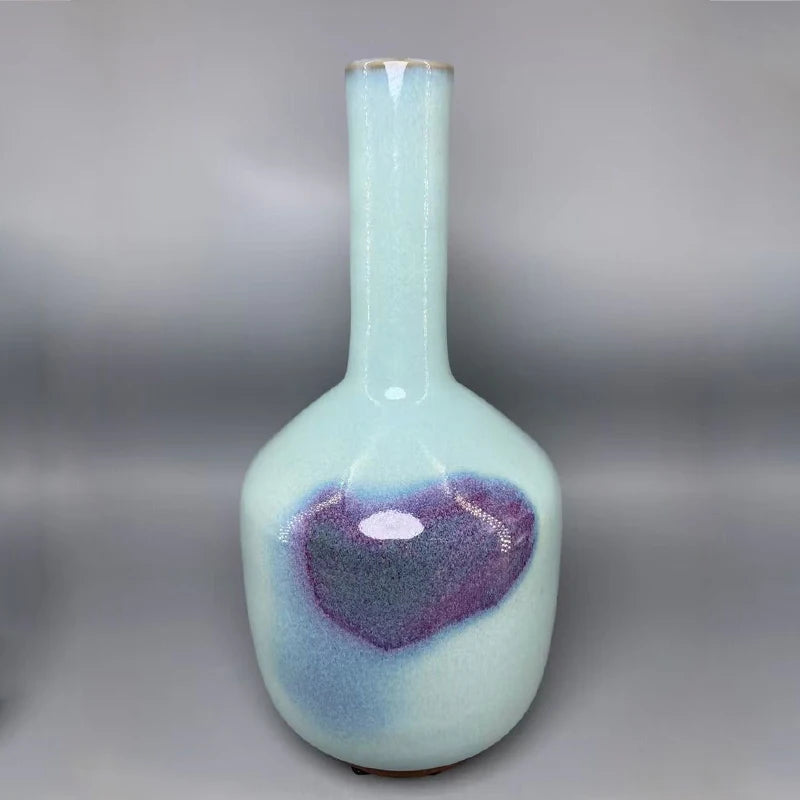 Un magnifique vase en porcelaine de couleur bleu-vert et violet, avec une forme élégante et un design moderne.