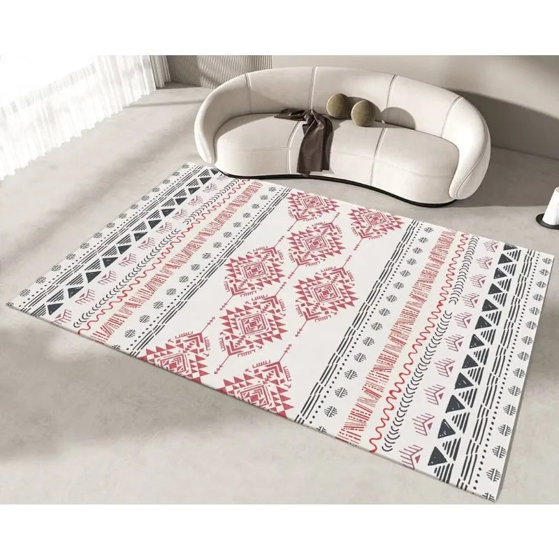 Tapis ethnique aux motifs géométriques rouges et noirs, décorant un intérieur moderne avec un canapé blanc.
