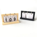 calendrier sculpture bois minimaliste moderne chiffres coulissants personne assise buste sphères blancs