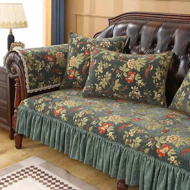 Un canapé en cuir marron foncé avec des coussins et une housse à motif floral vintage dans des tons verts et rouges, créant une ambiance cosy et chaleureuse dans cette pièce.