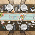 Une table de fête de Pâques joliment dressée avec des assiettes, des ustensiles et des décorations festives telles que des oeufs colorés et des tulipes.