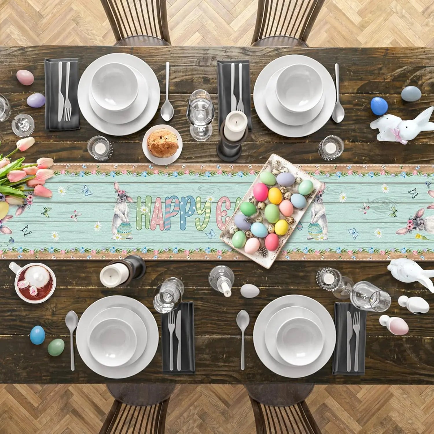 Une table de fête de Pâques joliment dressée avec des assiettes, des ustensiles et des décorations festives telles que des oeufs colorés et des tulipes.