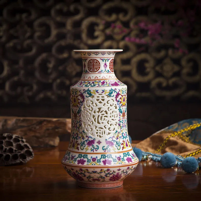 Vase décoratif en porcelaine de Chine avec motifs floraux colorés et design ajouré élégant, posé sur une table en bois sombre.