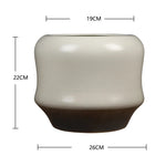 Vase décoratif en céramique de style moderne et élégant avec un design bicolore contrasté.