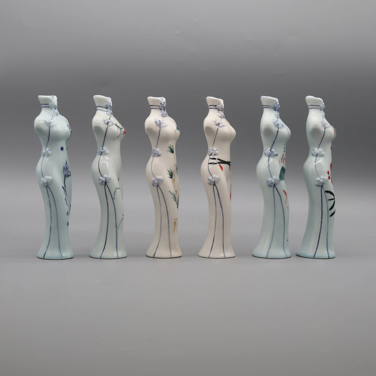 Une série de six figurines en céramique peintes à la main, représentant des formes féminines stylisées avec des motifs floraux et géométriques.
