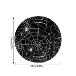 assiettes halloween araignées verres serviettes table noire blanc points brillants toile festive octobre