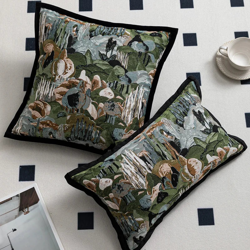 Deux coussins ornés de motifs colorés représentant une scène de nature sauvage avec des rochers, de la végétation et des animaux.