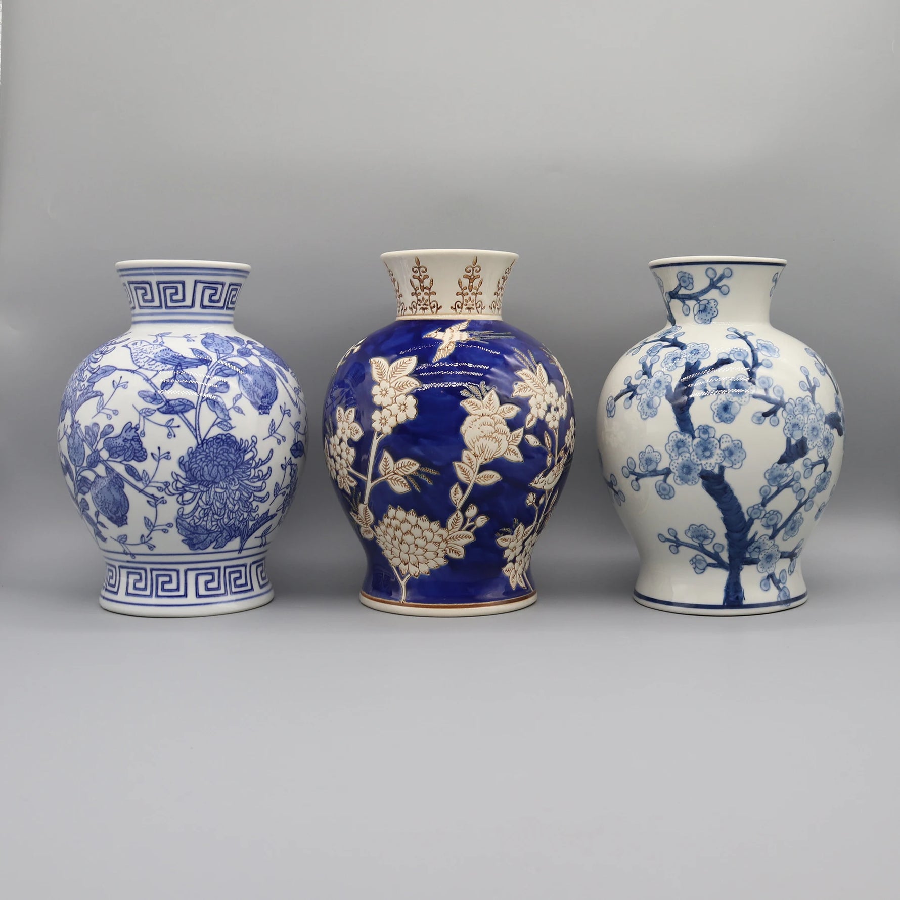 Cette image met en scène trois vases en céramique de style oriental, décorés de motifs floraux et géométriques bleus et blancs, illustrant la beauté et la finesse de l'artisanat traditionnel.