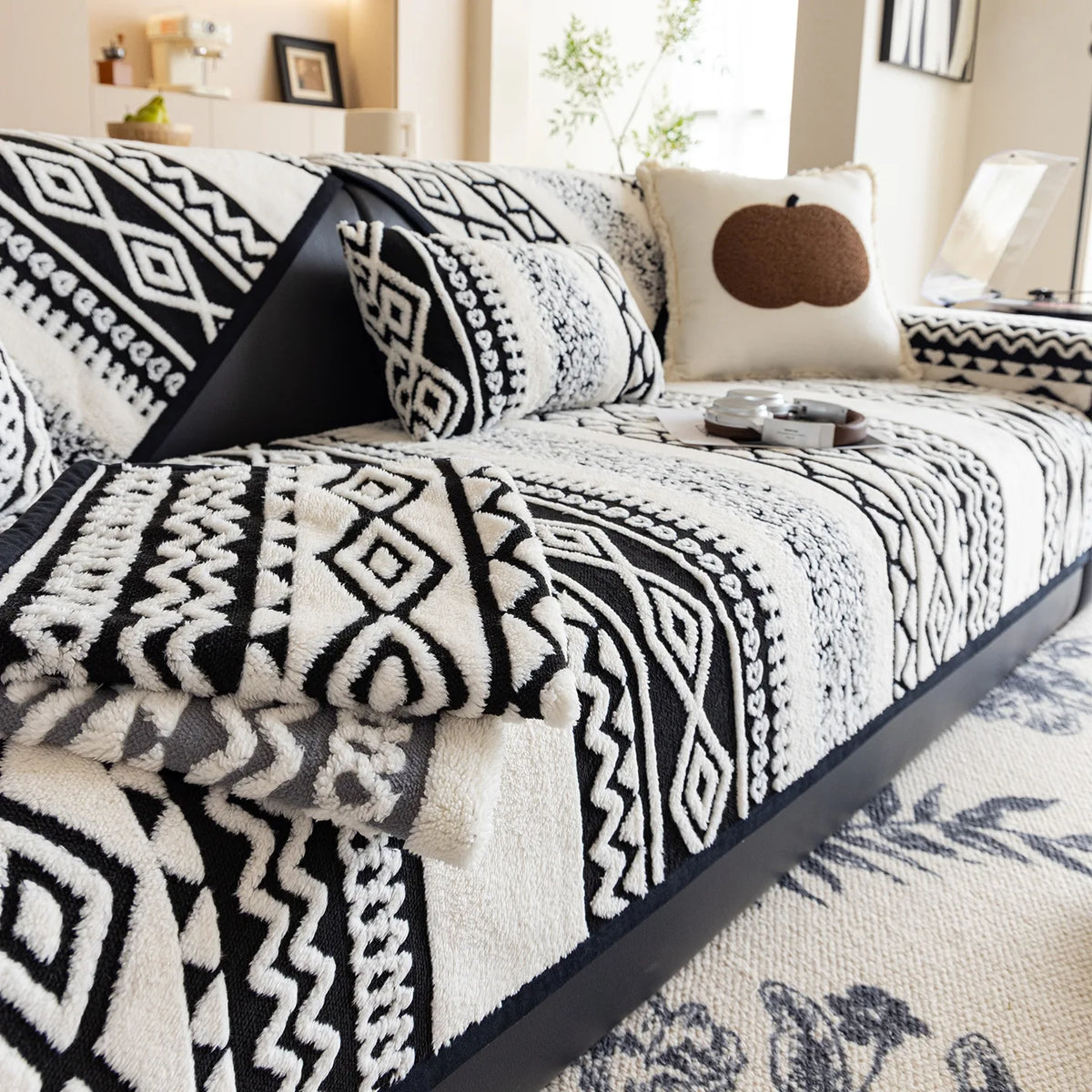 Ce lit montre un ensemble de draps et de taies d'oreiller avec un motif géométrique noir et blanc, créant une atmosphère décorative et élégante dans la chambre.