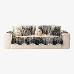 Canapé blanc et noir élégamment décoré de coussins et d'un accessoire rond, offrant un contraste visuel et une touche raffinée.