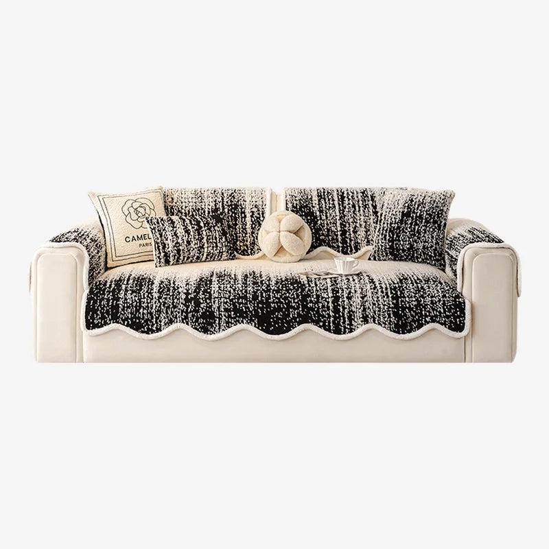 Canapé blanc et noir élégamment décoré de coussins et d'un accessoire rond, offrant un contraste visuel et une touche raffinée.