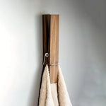 Porte-serviettes mural en bois noir avec serviette accrochée