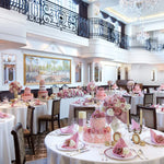 Une salle de réception élégante, décorée avec des arrangements floraux roses et des lustres étincelants, offrant un cadre luxueux pour un événement spécial.