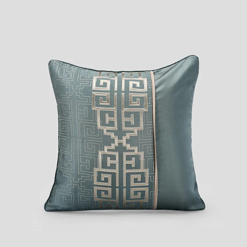 Coussin décoratif en satin de couleur vert grisé avec un motif géométrique élégant.