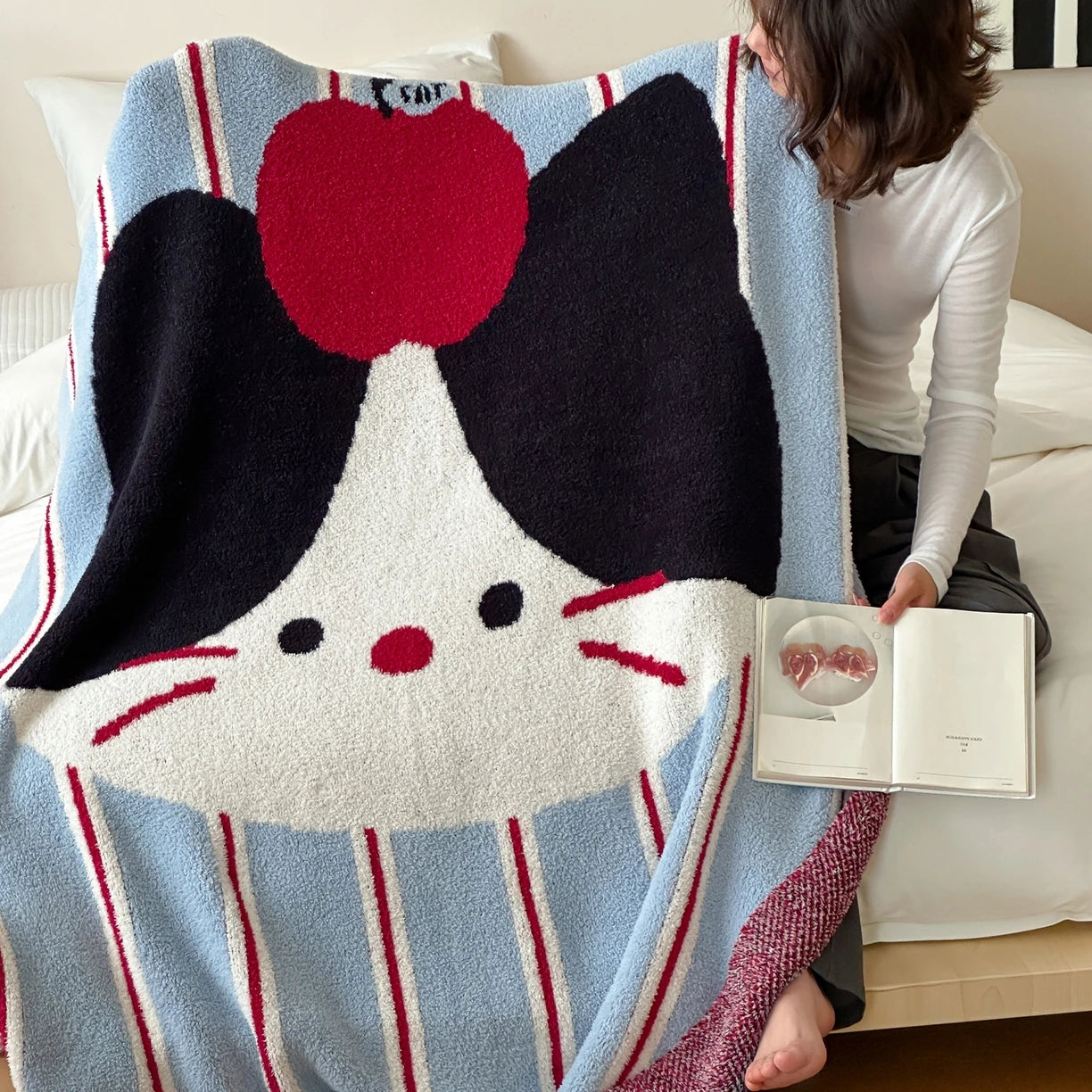 Couverture en peluche douce avec un motif graphique représentant un personnage de dessin animé avec des oreilles de chat et un coeur rouge.