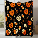 Couverture noire avec des motifs orange d'Halloween, tels que des citrouilles, des crânes et des bonbons.