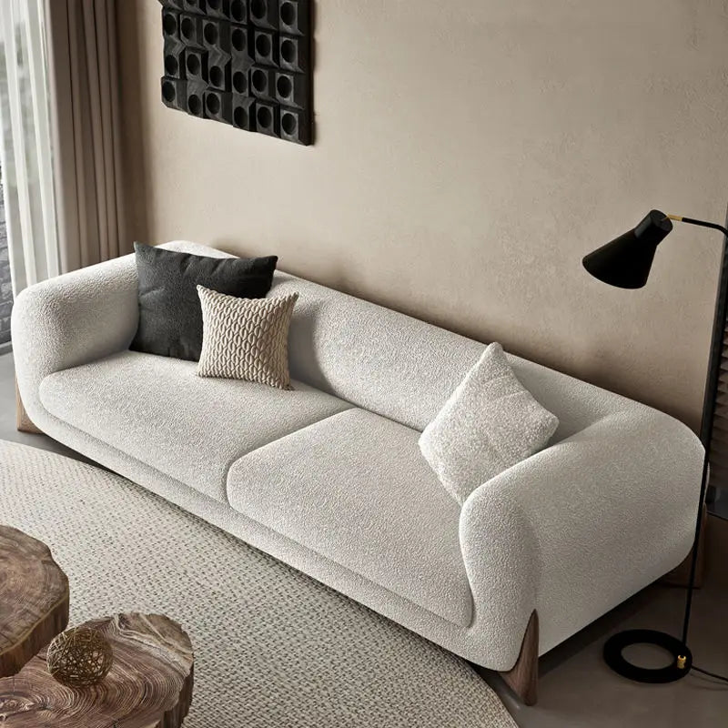 canapé moderne cuir synthétique beige clair coussins tissu bouclé salon familial