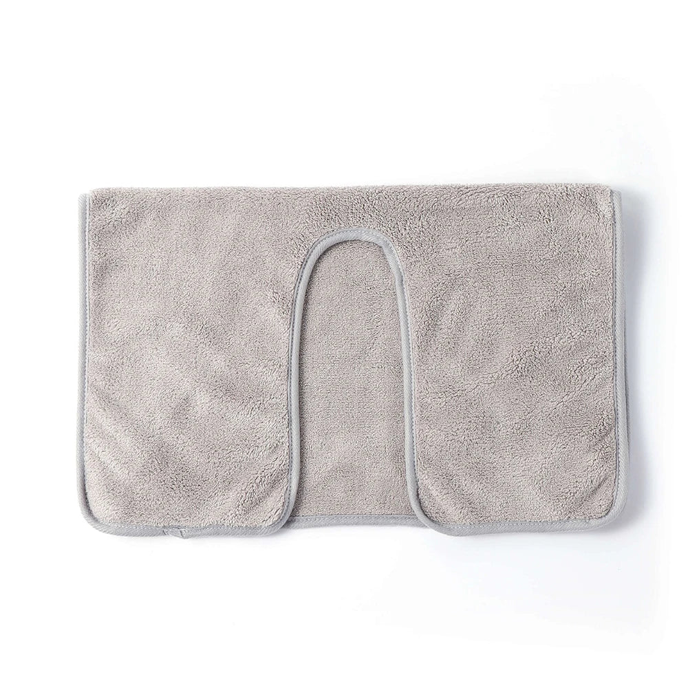 Un tapis de bain moelleux et gris clair avec une forme d'arc.