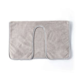 Un tapis de bain moelleux et gris clair avec une forme d'arc.