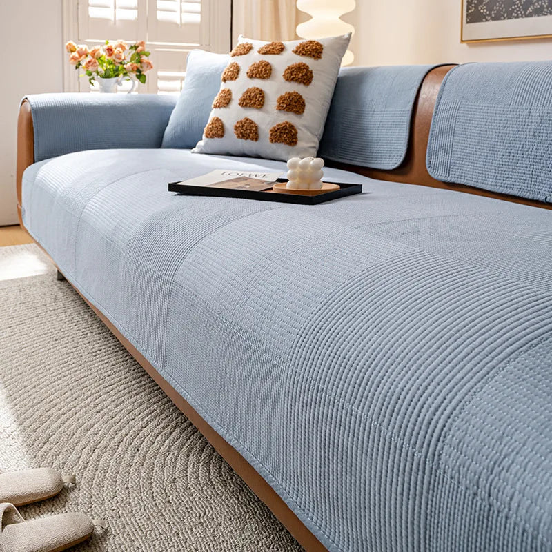 Un beau canapé gris dans un intérieur lumineux, avec des coussins décoratifs et une table basse en bois sur un tapis beige.