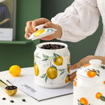 Un récipient blanc décoré de citrons jaunes est rempli de grains de café torréfiés, évoquant les arômes et les textures d'une boisson corsée et revigorante.