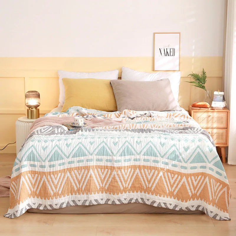 Une chambre à coucher confortable et harmonieuse avec un motif géométrique sur la couverture de lit et des accents de couleurs douces.