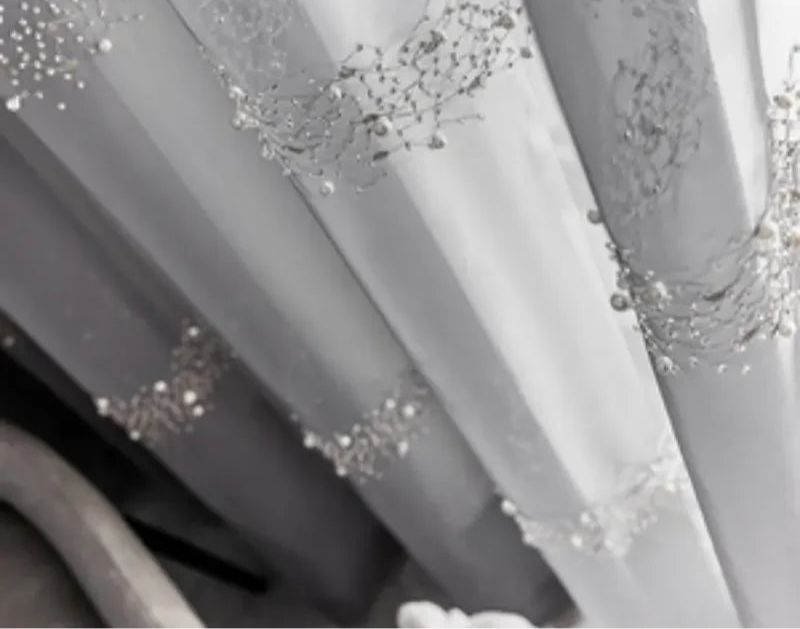 Rideau voilage gris clair avec décor perlé sur fenêtre style français.