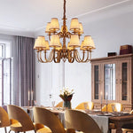 chandelier bronze classique suspension lumière abat jours tissu texturé courbes salle manger