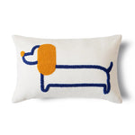 Coussin décoratif en forme de chien teckel avec des motifs bleus et orange sur un fond blanc.