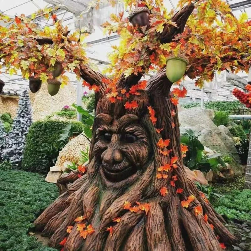 sculpture arbre anthropomorphique feuilles colorées marron vert orange texture bois yeux jaunes sourire