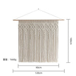 tapisserie macramé boho chic motifs géométriques franges beige clair tige bois crochets métalliques