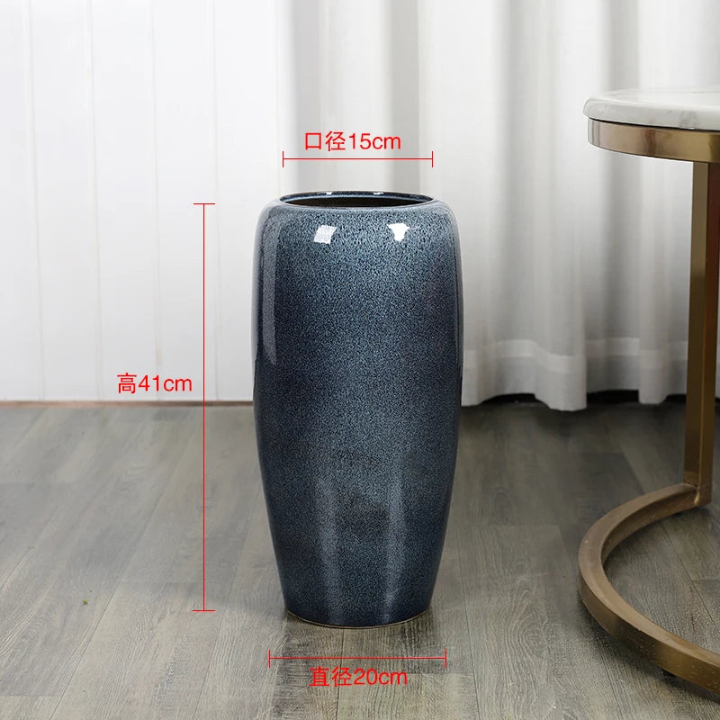 Un vase décoratif de grande taille en céramique grise avec un motif granuleux et des dimensions de 41 cm de hauteur et 15 cm de diamètre.