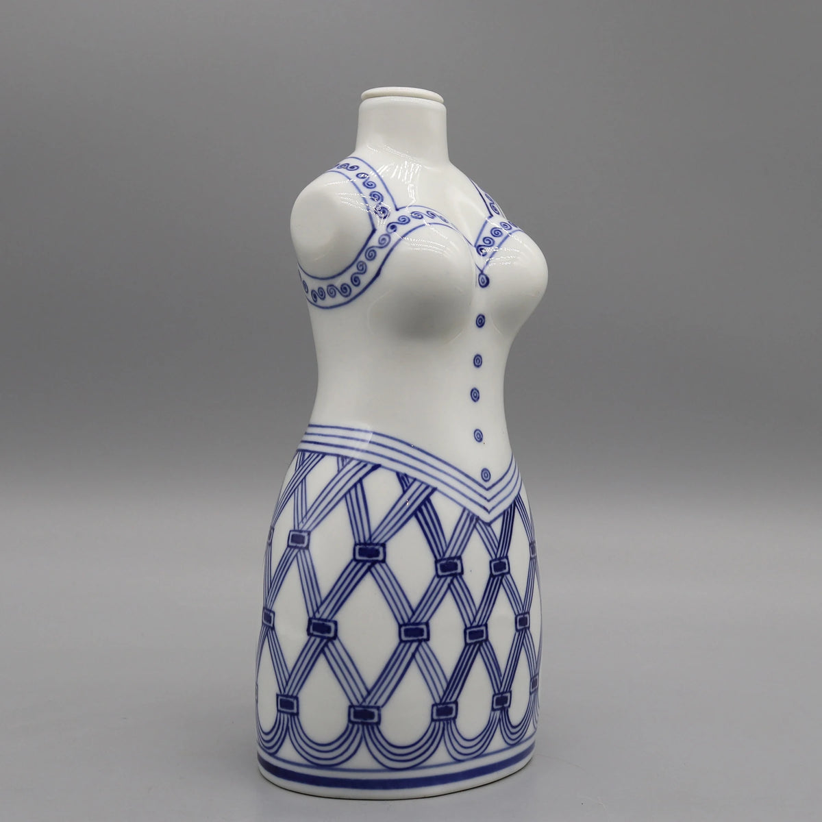 Un vase décoratif en céramique blanche avec un motif de lignes et de formes géométriques bleu marine imprimé sur sa surface.