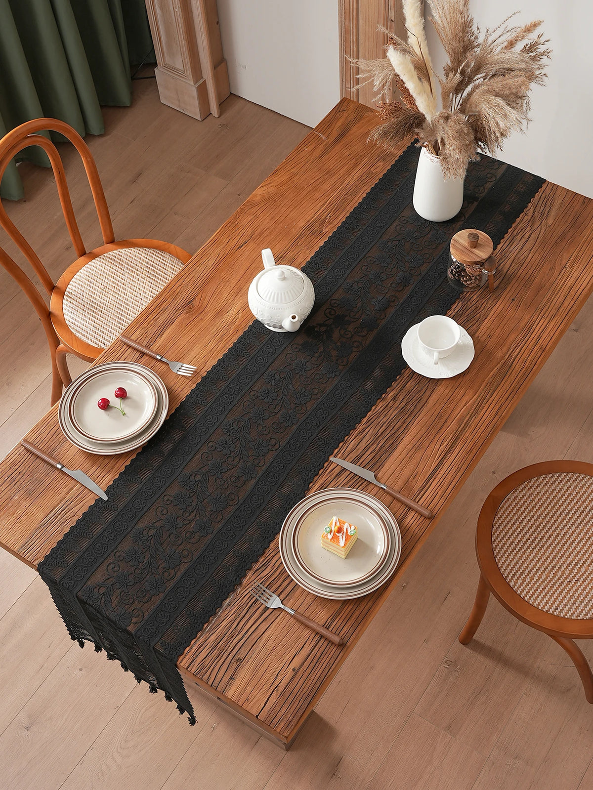 chimene table noir dentelle motif floral bordures franges assiettes couverts tasse théière gâteau cerises