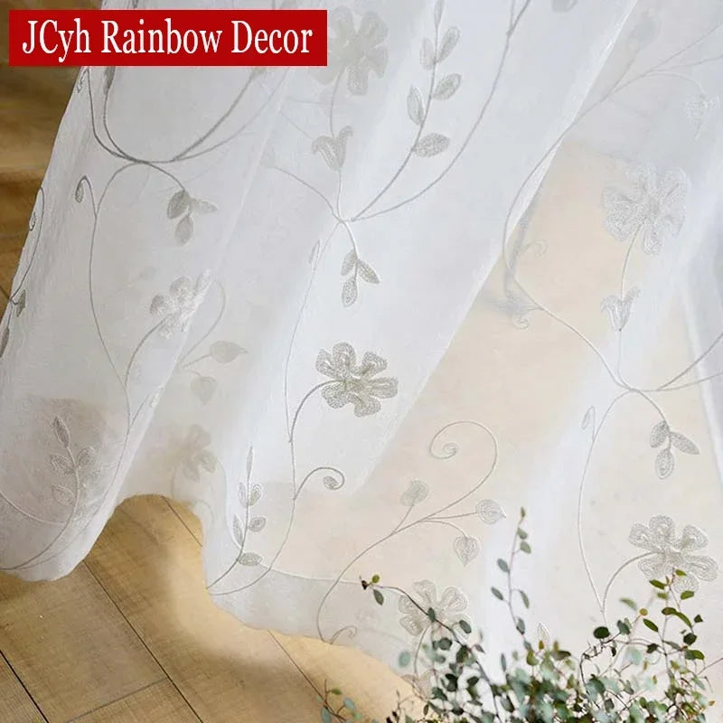 Détail de la broderie florale sur le voile blanc décoratif