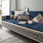 Un confortable canapé bleu profond décoré de coussins gris et beige aux motifs graphiques, offrant un look chic et sophistiqué dans cet intérieur lumineux.