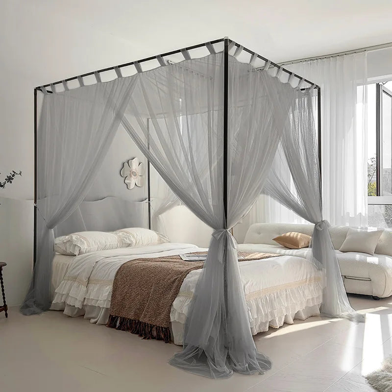 Élégante chambre blanche et grise avec un lit à baldaquin orné de rideaux légers, offrant un environnement paisible et confortable.