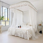 Ce lit à baldaquin élégant avec un drap de lit blanc et des rideaux aériens crée une atmosphère romantique et apaisante dans cette chambre lumineuse et aérée.