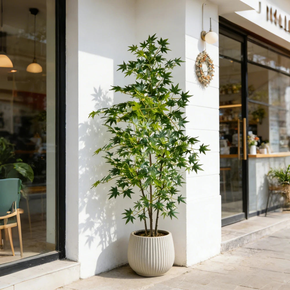 plante artificielle arbuste feuilles vertes feuilles pointues tronc droit pot beige décoration intérieure moderne