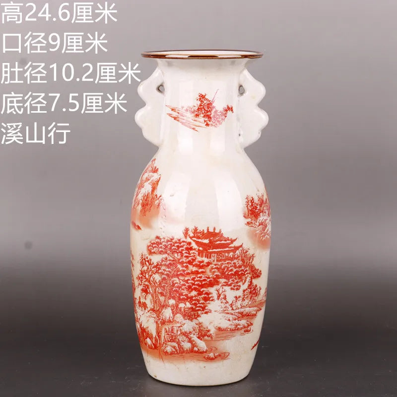 Un vase en porcelaine blanche décoré de motifs paysagers rouges, orné de personnages et de bâtiments traditionnels chinois, offrant une esthétique traditionnelle et élégante.