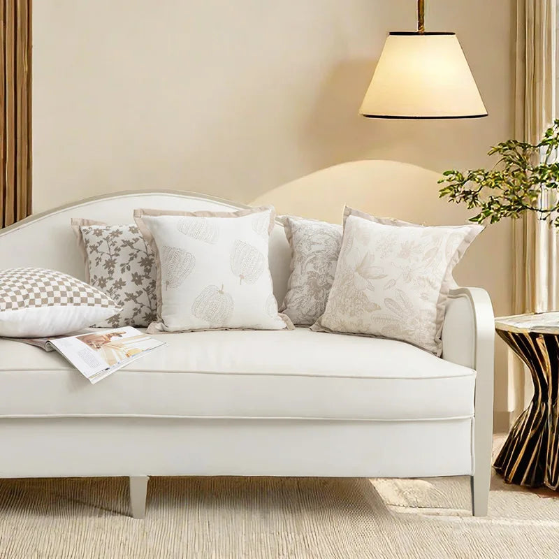 Un canapé confortable et élégant avec des coussins décoratifs dans une chambre chaleureuse et bien éclairée.