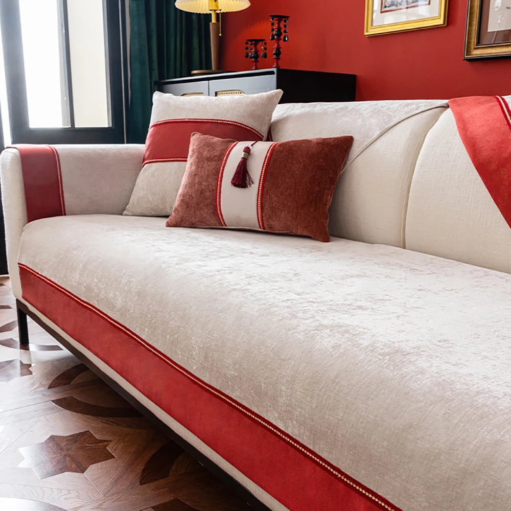 Un confortable canapé beige et rouge assorti de coussins décoratifs et d'un cadre sur le mur.