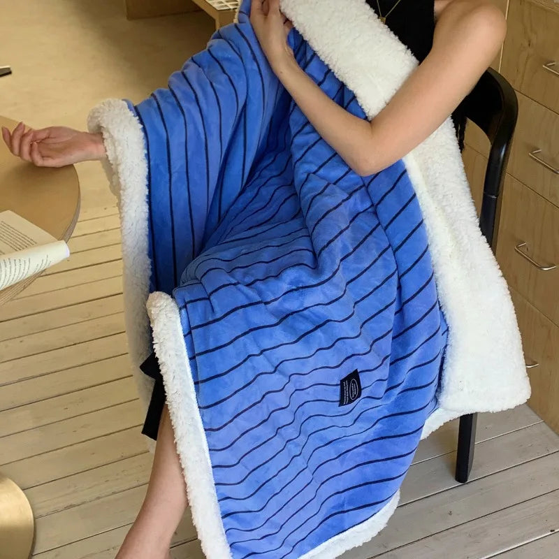 Une couverture en flanelle douce et rayée de bleu, conçue pour procurer chaleur et confort.