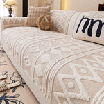 Cette image montre un canapé décoré avec un motif ethnique dans des tons beiges et blancs, avec des coussins et un oreiller décoratifs. Le canapé semble confortable et douillet dans cet environnement cocooning.