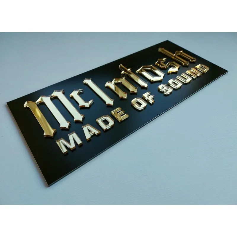 plaque publicitaire rectangulaire noire dorée lettres relief élégante salle cinéma moderne