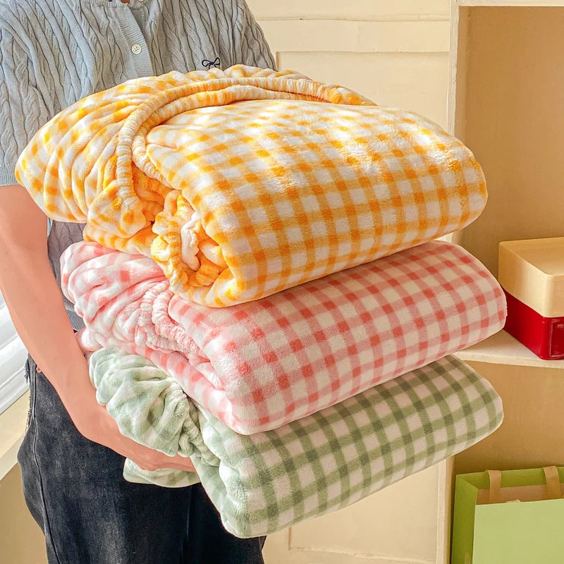 De chaleureuses couvertures à carreaux dans des couleurs douces et apaisantes, empilées soigneusement pour créer une scène cocooning et confortable.