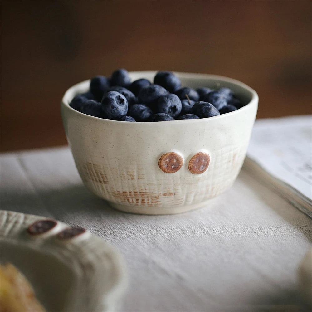 Bol en céramique rempli de baies de myrtille fraîches sur un fond neutre.